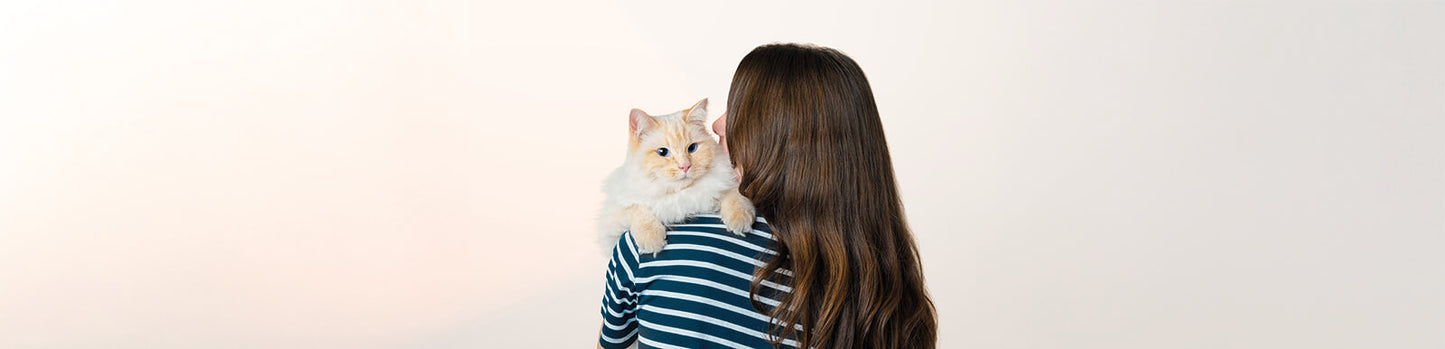 Woman holding cat representing quality pet food NZ and cat care